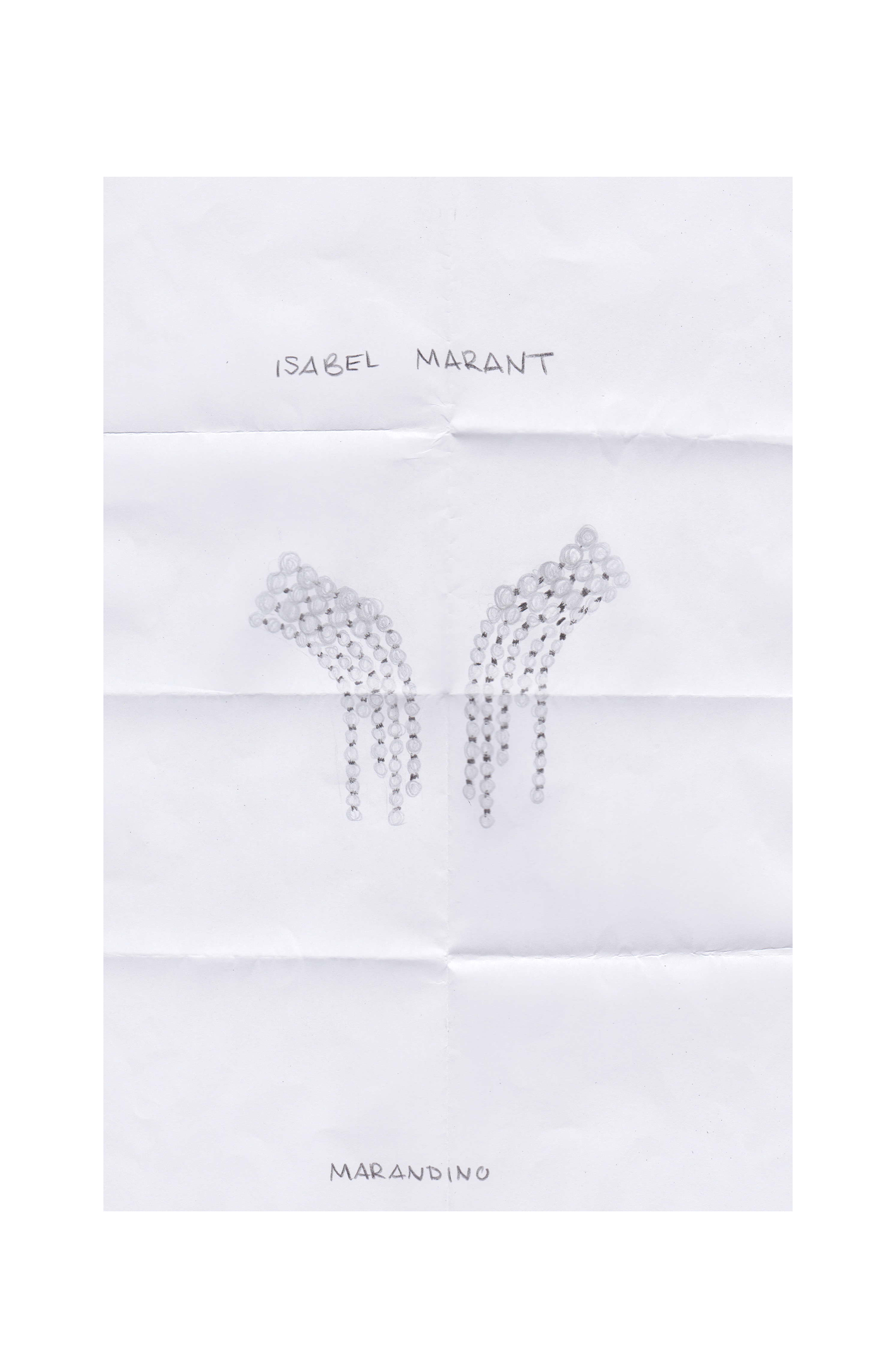 Ein Stück weißes Papier mit einem Paar silberner  Isabel Marant Ohrringe darauf