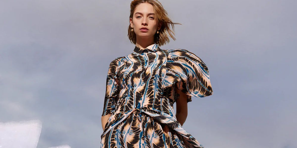 Eine Frau steht vor einem Baum mit rosa Blumen 