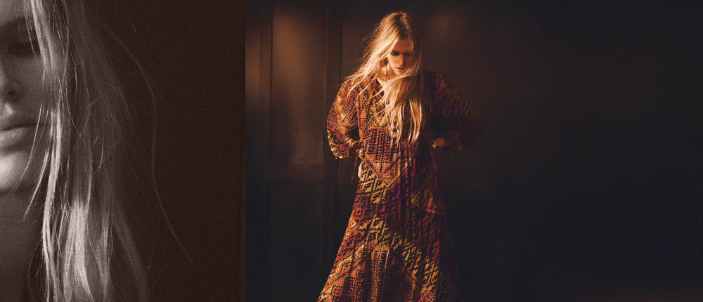 Eine Frau sitzt auf dem Boden und hält eine schwarze Tasche