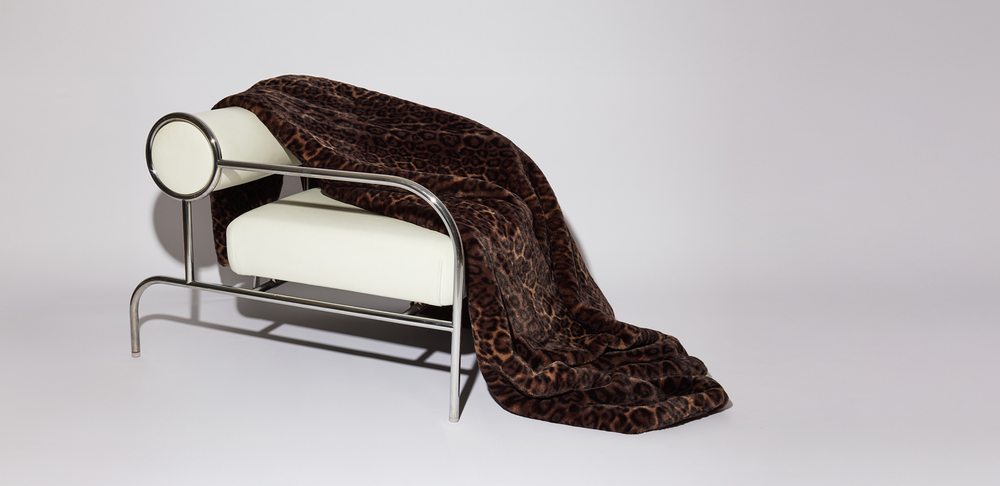 Eine Frau mit braunem Teddy Mantel in einer Stadt mit anderen Jacken zu sehen