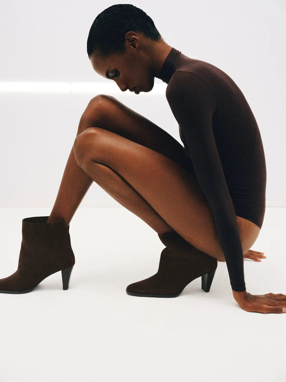 Eine Frau mit silbernen Schuhen der Marke Lola Cruz sitzt auf dem Boden