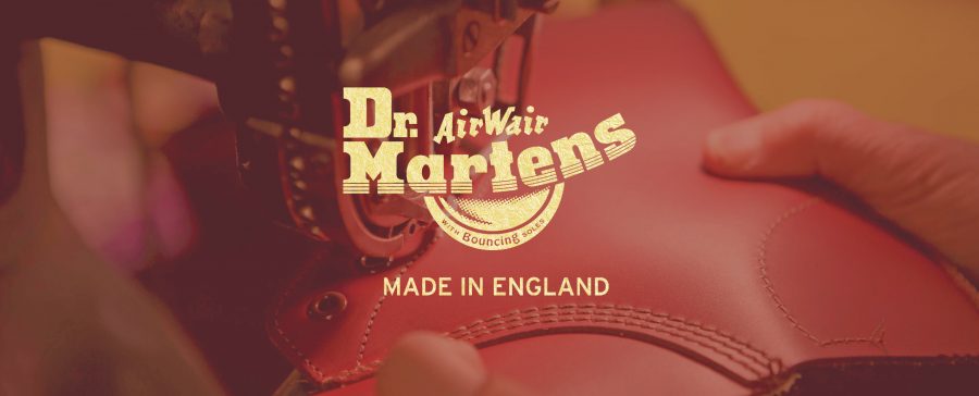 Eine Person hält einen Stiefel mit der Aufschrift dr martin's made in england