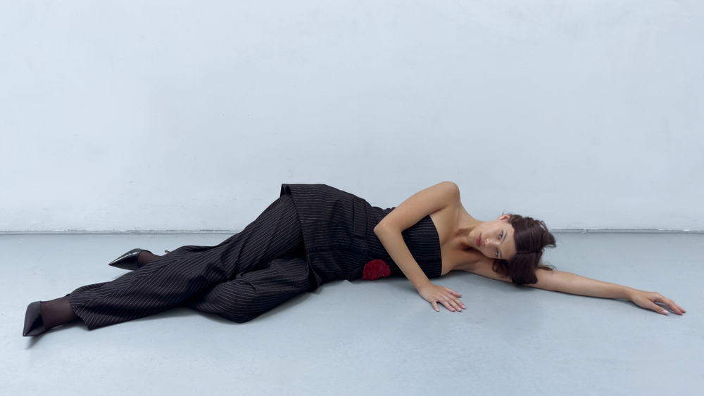 Eine Frau im Bikinioberteil auf einem Balkon stehend