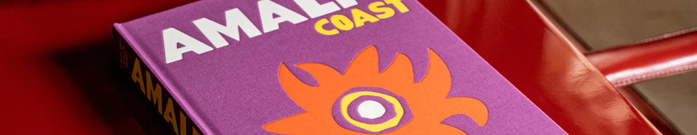 Ein Detailbild von einem Buch der Marke Assouline auf einem roten Tisch