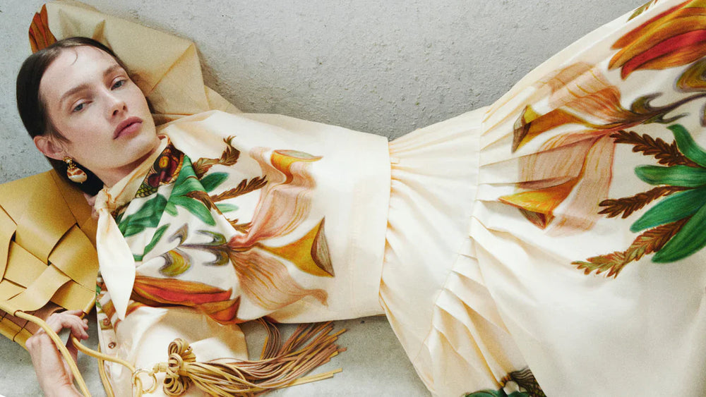 Eine Frau steht vor einem Baum mit rosa Blumen 