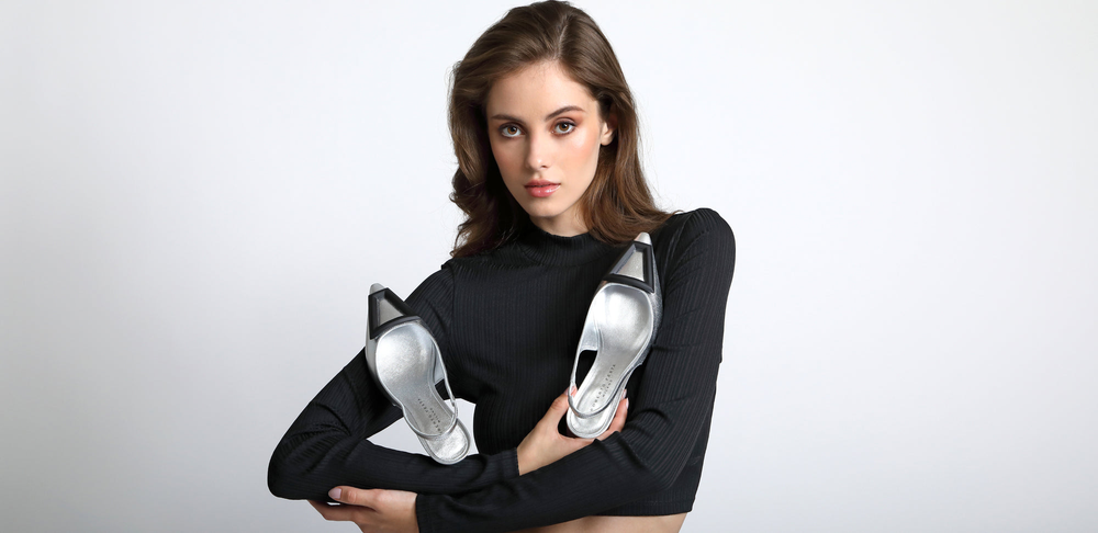 Eine Frau sitzt auf einer Couch und hält eine Handtasche