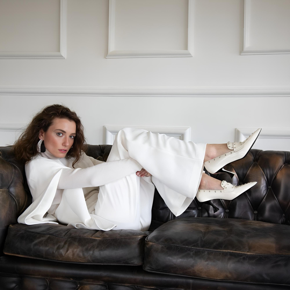 Eine Frau sitzt mit gekreuzten Beinen auf einem Stuhl