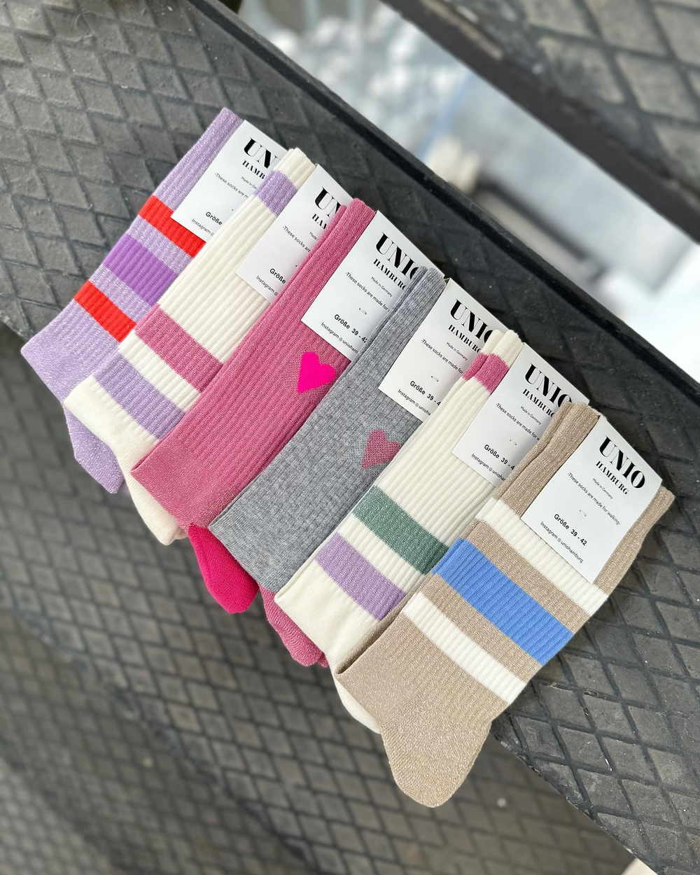 Fünf Paar Socken hängen auf einer Stange