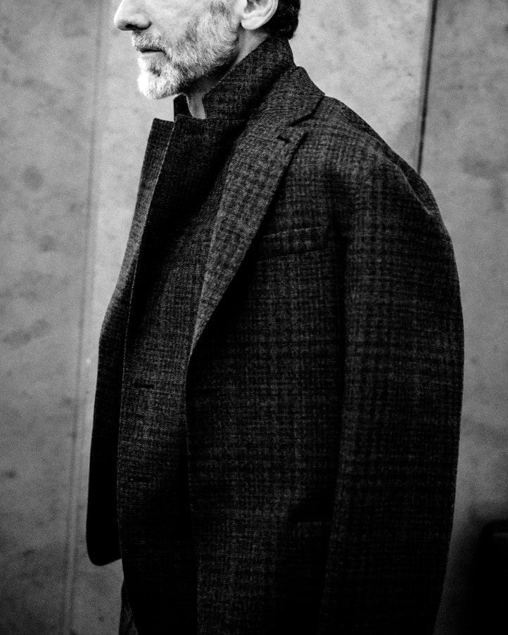 Ein Mann mit blondem Haar steht vor einer Wand