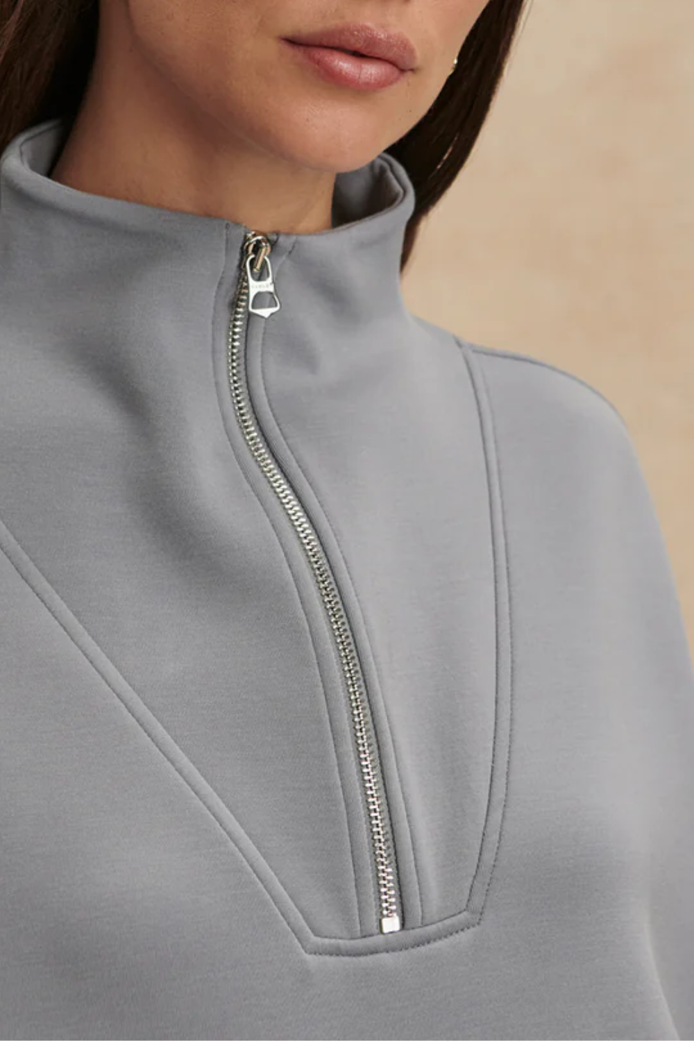 Frau trägt oversized Fit Sweatshirt mit halbem Reißverschluss, tiefen Ärmelbündchen und breitem Saumbund in babyblau