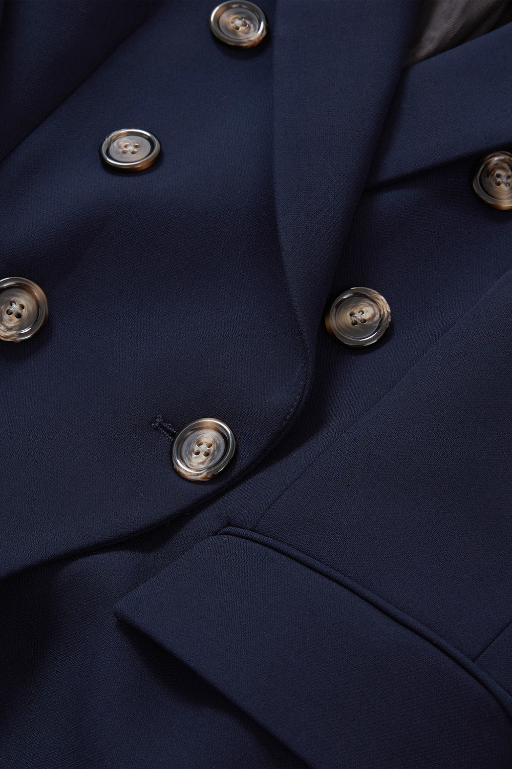 Close up: Schlanker, dunkelblauer Blazer mit doppelreihiger Knopfleiste und Hornknöpfen aus feinem Suiting-Material mit leichtem Stretch