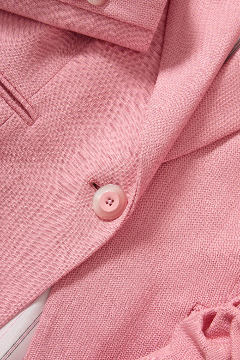 Close up: Einreihiges rosafarbenes Sakko mit klassischem Revers, vorgekräuselten Ärmeln und feiner Slub-Struktur aus hochwertigem Stretch-Material