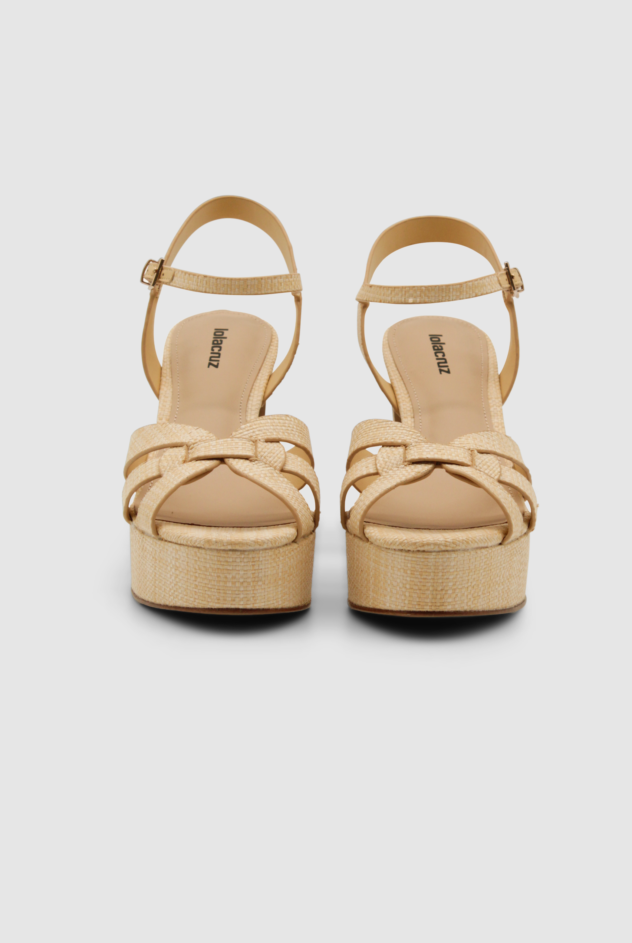Sandalen von Lola Cruz mit einer Plateausohle und geflochtenen Riemen an den Zehen. Die Schuhe haben einen Riemen an der Ferse und haben einen hohen Absatz