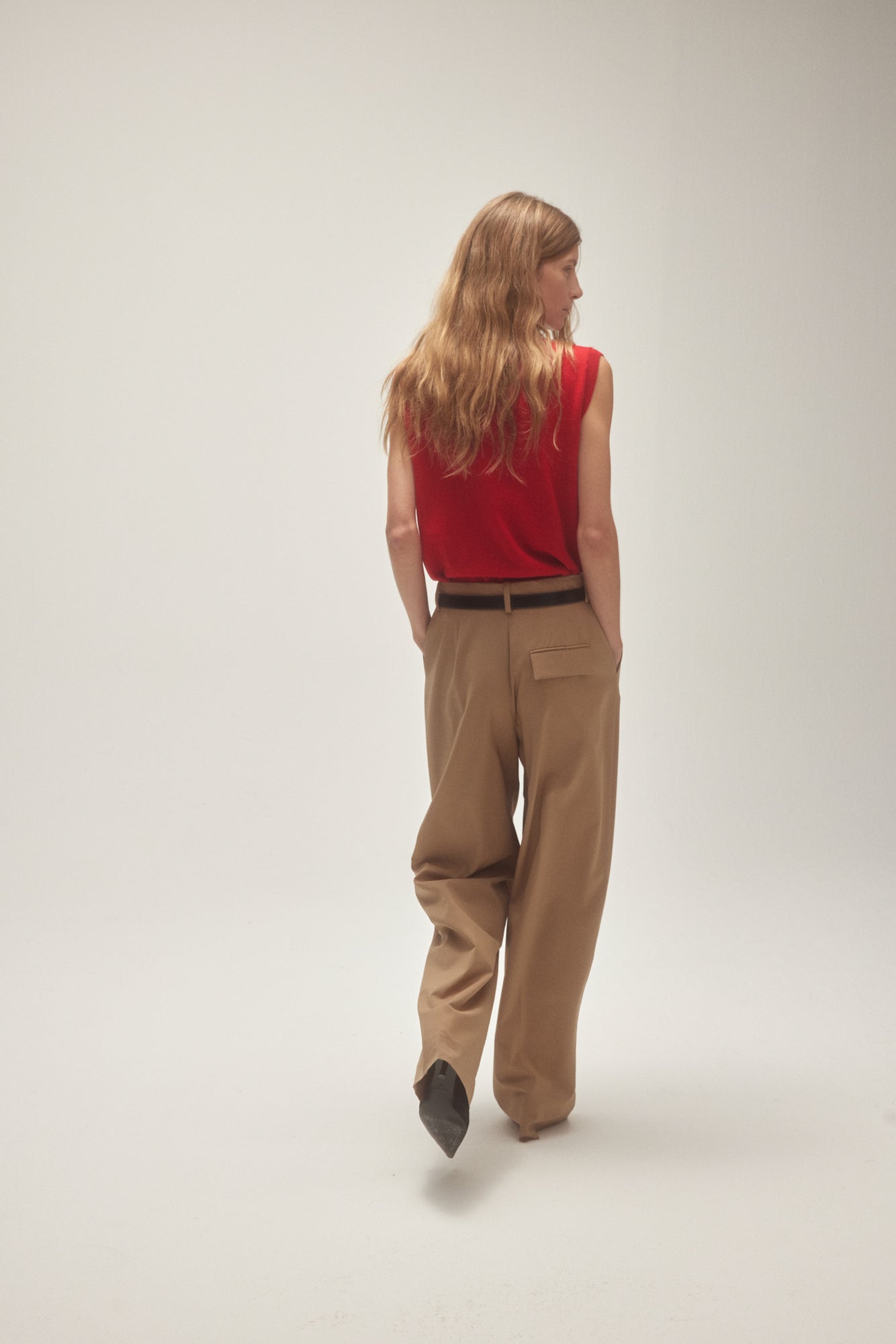 Róhe Model von hinten mit beige Hose und roter Pullover