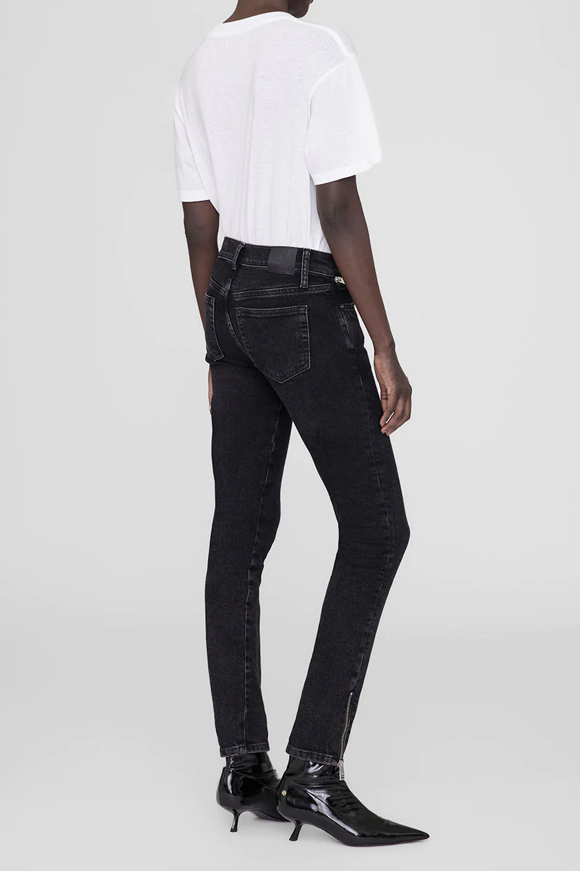 A woman wearing black jeans and a white t - shirt