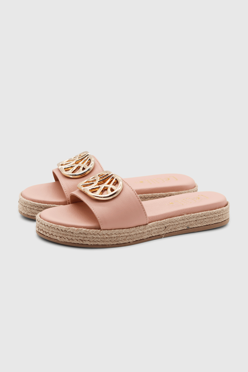 Ein Paar rosa Sandalen mit einer goldenen Schnalle